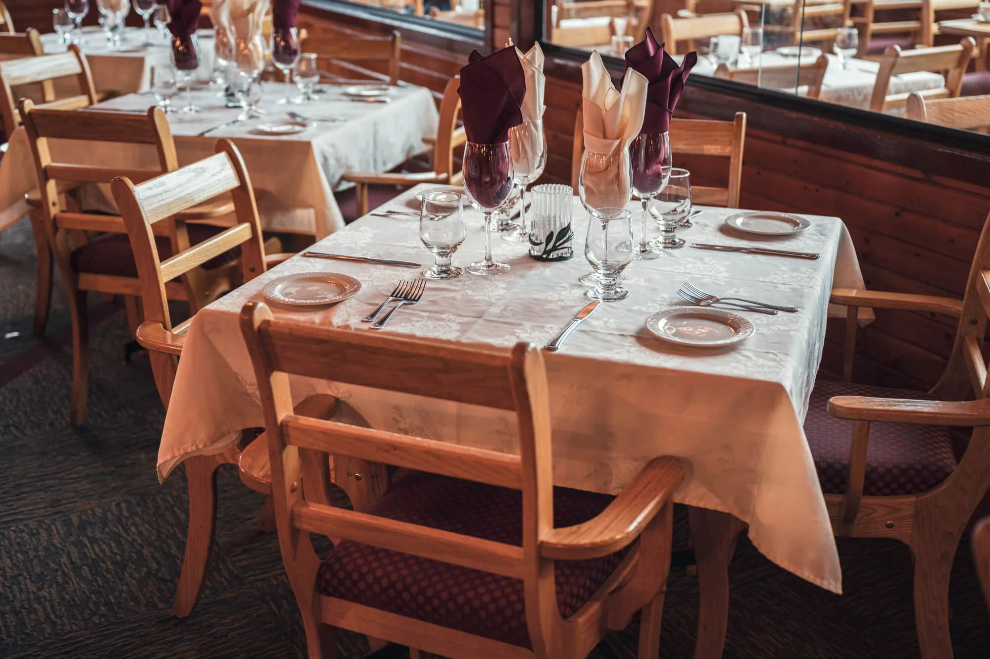 A rustic wooden table laid with plates and cutlery